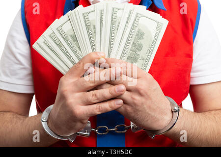 Closeup of male supermarket or hypermarket male employee holding bribe money in handcuffed hands isolated on white Stock Photo