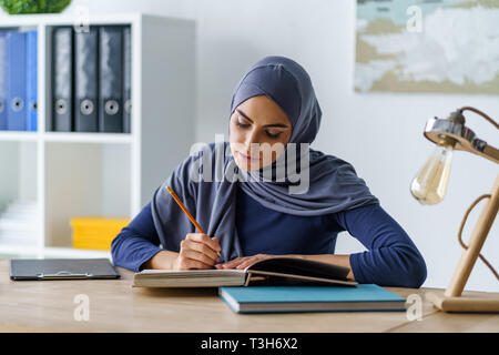 Muslim woman reading a book Stock Photo