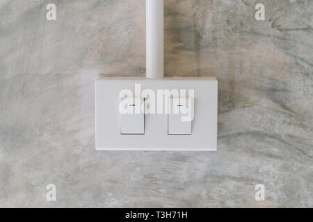 electrical light switch on cement wall background Stock Photo