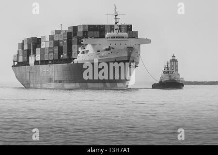 Black And White Photo Of The PASHA HAWAII Container Ship, HORIZON RELIANCE, Entering The Los Angeles Main Channel At The Angels Gate Lighthouse, USA Stock Photo