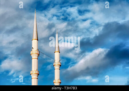 Mosque minaret, loudspeakers and ridge against a vibrant cloudy blue sky background with copyspace Stock Photo