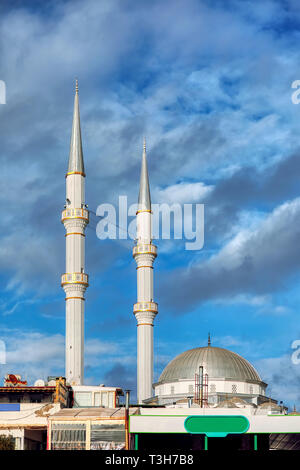 Mosque minaret, dome, loudspeakers and ridge against a vibrant cloudy blue sky background with copyspace Stock Photo
