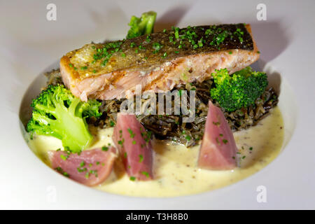 Grilled salmon served on a bed of seasonal vegetables.