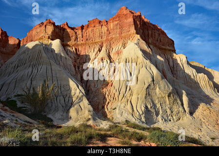 Gouged red and white cliffs that form a backdrop to the endless stretch of sand on Praia da Falesia beach, Albuferia, Algarve, Portugal, Europe. Stock Photo