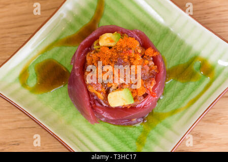 Sliced raw bluefin tuna sashimi arranged in an overlapping row on a ...