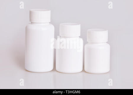 White blank medical plastic bottles of different sizes on a white background. Studio lights Stock Photo