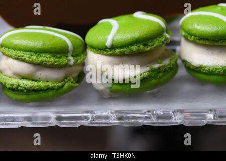 Green macarons hor' d'oeuvres filled with vanilla ice cream on crystal glass dish Stock Photo