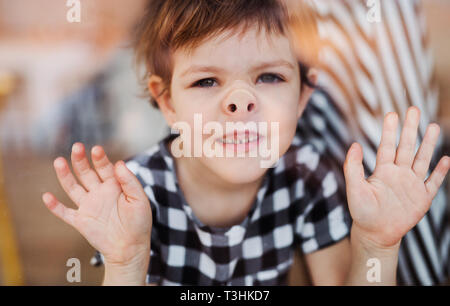 A close-up of a small girl looking through the window. Stock Photo