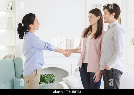 Professional psychologist and thankful couple handshaking in office Stock Photo