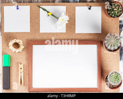 Workplace Mockup. Top view of scandinavian style. Three white stickers, empty photo frame, three cactus. cork background. Stock Photo