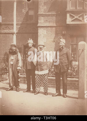 Vintage Edwardian Photographic Postcard Showing Four Men Standing To Attention Wearing Partial Fancy Dress Costumes. The Tunics Would Suggest That They Are Possibly Police Officers. Stock Photo