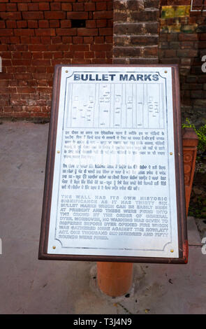 Sign about bullet marks in a brick wall, Jallianwala Bagh, a public garden commemorating the 1919 Jallianwala Bagh shooting Massacre, Amritsar, Punjab, India Stock Photo