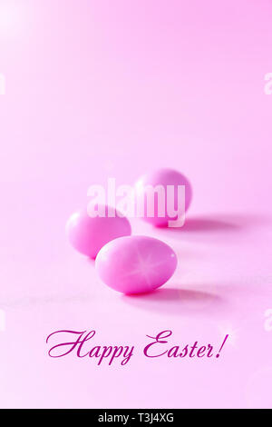 Three small pink eggs on pink background. Easter celebrate concept. Copy space. Stock Photo