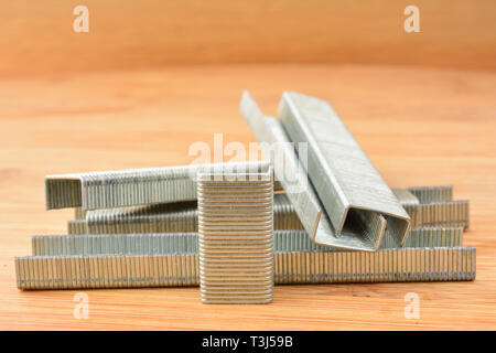 Strips of staples on bamboo wooden background, close up view, shallow depth of field Stock Photo