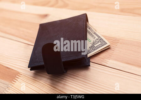 One dollar bill in leather wallet on the table, selective focus Stock Photo