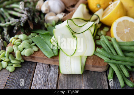 Fresh ingredients for pasta, zucchini, lima beans, green beans, lemon, garlic and homemade whole wheat pappardelle pasta. Stock Photo