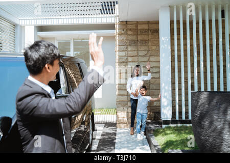 husband waving goodbye to his family before going to work Stock Photo