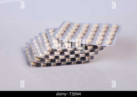 Medicine herbal pills or tablets in silver blisters on white background. Drug prescription for treatment medication. Antibiotic, painkiller closeup. Stock Photo