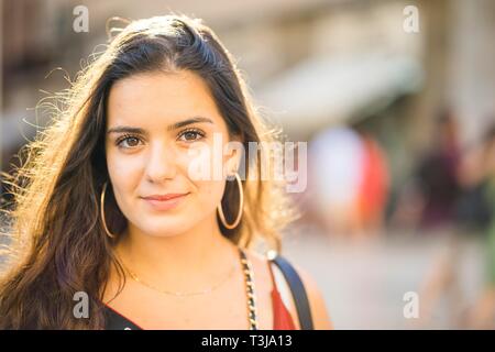 Portrait of young brunette woman in sunny urban setting, Portugal Stock Photo