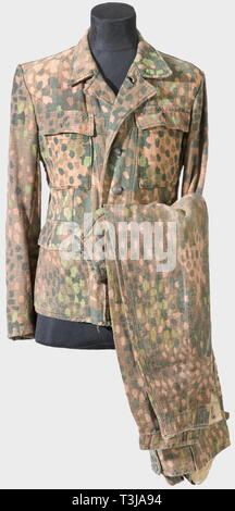 A field jacket for the M 43/44 drill uniform, in the spotted camouflage pattern Drill jacket printed on one side with the spotted camouflage pattern. First aid kit pouches and reinforcements of grey herringbone, bearing factory number and size stamps. Metal buttons (incomplete). Recently washed. Also a pair of trousers of matching camouflage pattern, made for collectors. historic, historical, 1930s, 20th century, Waffen-SS, armed division of the SS, armed service, armed services, NS, National Socialism, Nazism, Third Reich, German Reich, Germany, military, militaria, utensi, Editorial-Use-Only Stock Photo