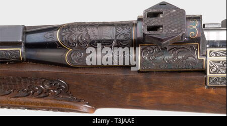 A splendid repeating rifle Mauser 66, cal..30-06, no. SG 50637. Mirror-like bore, length 55.5 cm. Telescope lock. Magazine for two cartridges. Set trigger. Masterly tendrilengravings and gold thread inlay on receiver. Gold inlay on front sight. Richly carved full stock made of figured root wood with hog-back stock, Bavarian cheek-piece with double moulding and Kaiser grip. Cap and nose made of buffalo horn. Scope ZF Zeiss Diavari VM 2.5 - 10 x 50 (reticule 4) on frog mount. Total length 99 cm. Weapon and scope in very good quality. Exclusive luxu, Additional-Rights-Clearance-Info-Not-Available Stock Photo