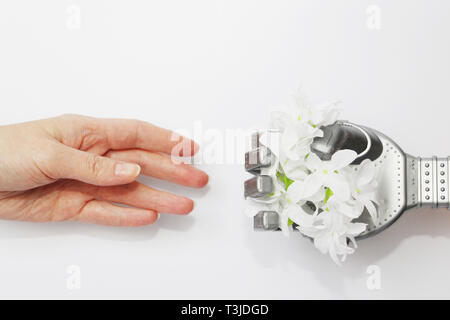 Robot and man. A robot hand gives a real person a flower. Modern technology and robotics. Robots and people nearby. Concept. Stock Photo