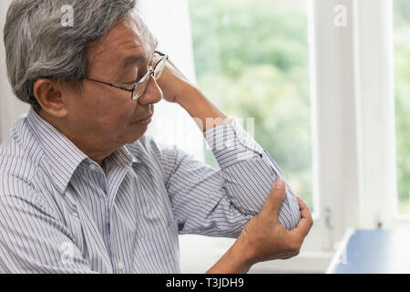 asian elder suffer golf elbow pain Stock Photo