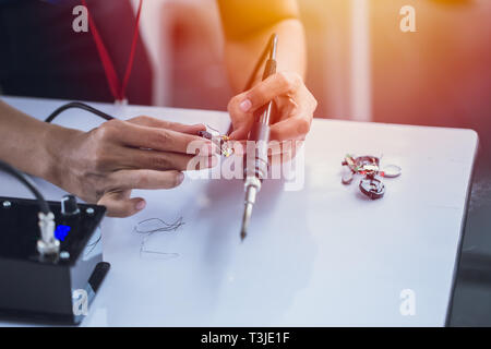 electornic engineer using soldering iron to making small circuit robot hardware. Stock Photo