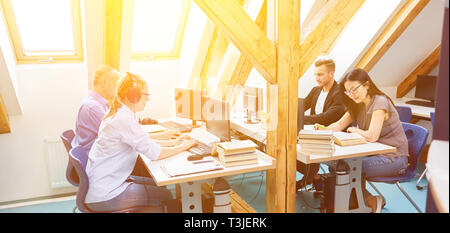 Group of people works together as a startup team in the office on computers Stock Photo