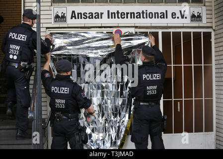 10 April 2019, North Rhine-Westphalia, Düsseldorf: Police officers install a privacy screen in front of the Ansaar International building in Düsseldorf. Police raids in nine federal states on Wednesday against institutions of a nationwide Islamic network Photo: Martin Gerten/dpa Stock Photo