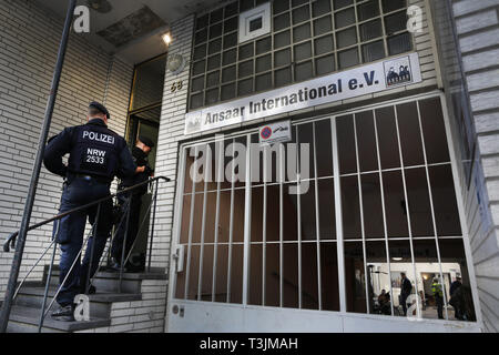 10 April 2019, North Rhine-Westphalia, Düsseldorf: Police officers are standing in front of the entrance to the Ansaar International building in Düsseldorf. On Wednesday, the police will raid nine federal states against institutions of a nationwide Islamic network. Photo: Martin Gerten/dpa Stock Photo
