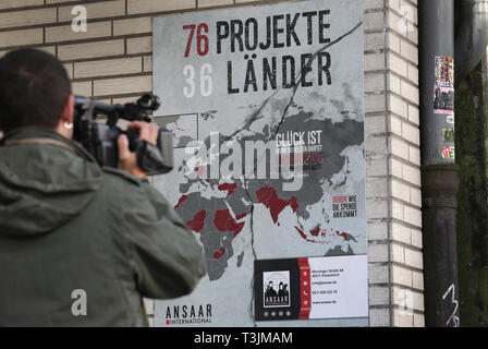 10 April 2019, North Rhine-Westphalia, Düsseldorf: A cameraman films a sign in front of the Ansaar International building in Düsseldorf. On Wednesday, the police will raid nine federal states against institutions of a nationwide Islamic network. Photo: Martin Gerten/dpa Stock Photo