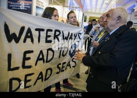 Warsaw, Mazowieckie, Poland. 10th Apr, 2019. Guests of the Poland Water Expo Conference are seen speaking to activists holding a big banner during the exhibition and conference. During the Water Expo Poland International Exhibition and Conference, a group of ecological activists from Extinction Rebellion unexpectedly stripped off to highlight how dangerous for the environment is building canals and waterways on rivers. Water Expo is Poland's only exhibition and conference event to comprehensively cover all aspects of investments linked to inland waters. (Credit Image: © Attila Husejnow/S Stock Photo