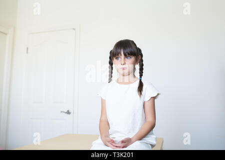 6-7 year old child is looking away. She is thoughtful. Stock Photo