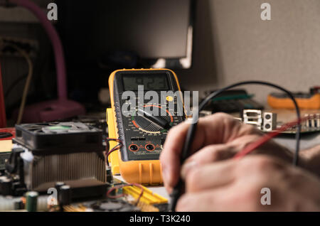 electronics technician is testing a computer chip. PC repair Stock Photo
