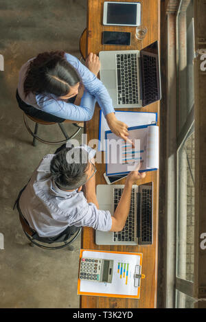 Two business employees discuss about financial data on report Stock Photo