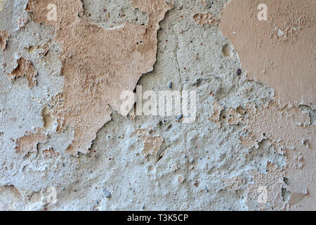 Oldgrungy weathered wall background texture. Dirty peeled plaster wall with falling off flakes of paint Stock Photo