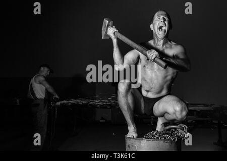 Screaming man with sledgehammer on an oil drum Stock Photo