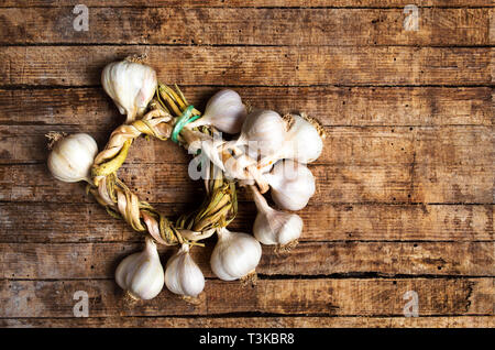 Garlic wreath on a rustic wooden table top view Stock Photo