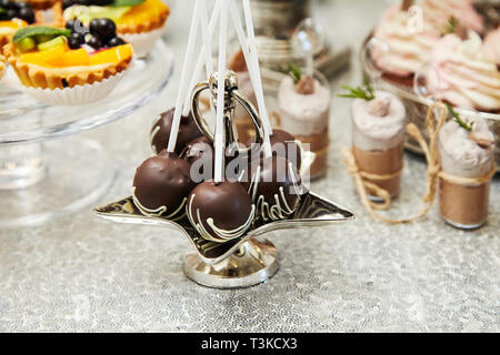 Candy bar. Festive table with deserts,  tartlets, cookies and cakepops. Stock Photo