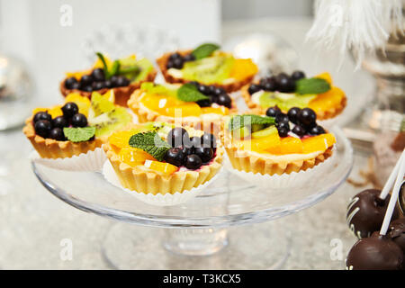 Candy bar. Festive table with deserts,  tartlets, cookies and cakepops. Stock Photo