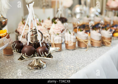 Candy bar. Festive table with deserts,  tartlets, cookies and cakepops. Stock Photo