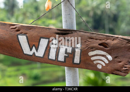 Text wi fi on a wooden board in a tropical cafe, Bali island, Indonesia. Wi-fi wooden sign inscription in the asian restaurant. Close up Stock Photo