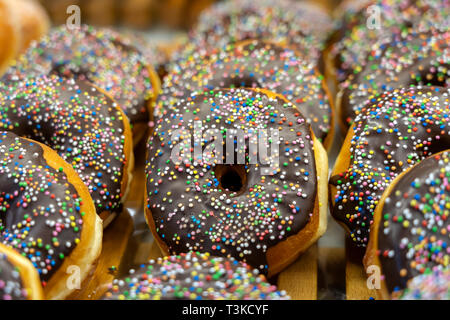 Pastries concept. Donuts with chocolate glaze with sprinkles, background, close up Stock Photo