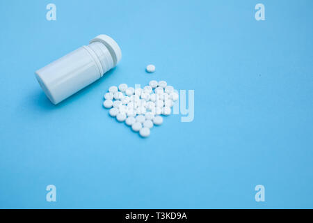 medicine, healthcare and pharmacy concept - pills and of drugs in shape of the heart white tablets are laid out in the shape of a heart and white plas Stock Photo