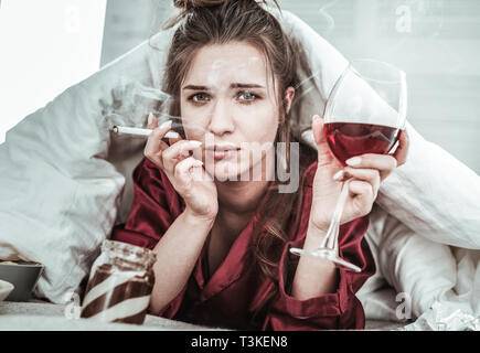 Stressed woman performing bad habits while being depressed Stock Photo