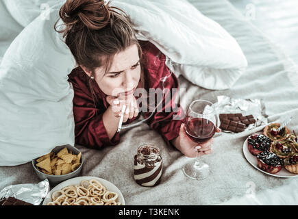 Woman performing bad habits while being depressed Stock Photo