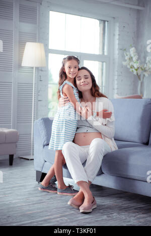Pregnant woman feeling happy spending time with daughter Stock Photo