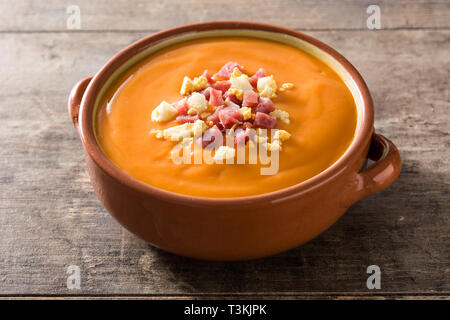 Typical Spanish salmorejo cream with ham and egg on wooden table. Stock Photo