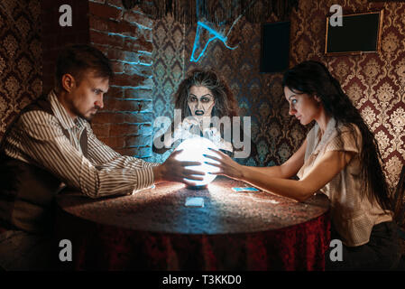 Foreteller calls the spirits over a crystal ball Stock Photo
